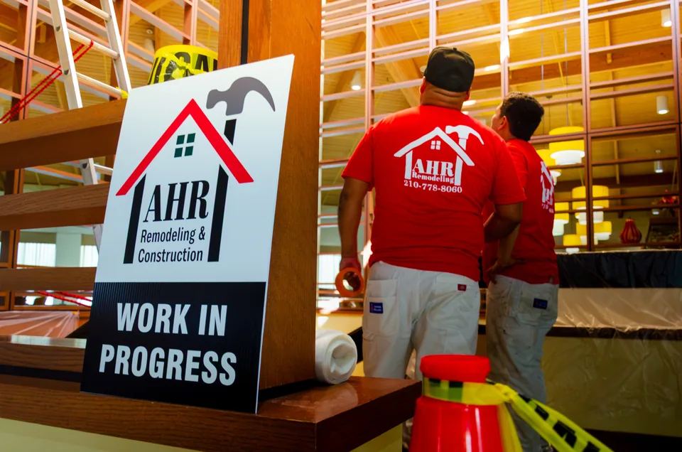 AHR crew at work inside a commercial building, beside a posted 'Work in progress' sign.